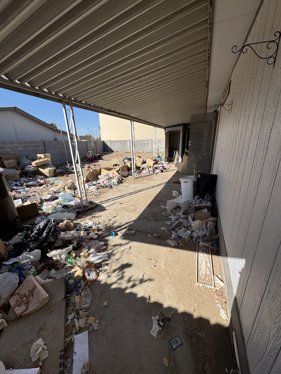 Covered patio with scattered debris before cleanup
